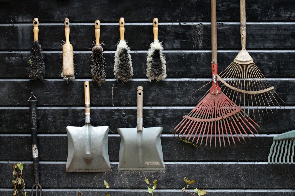 Garden tools neatly arranged on a rustic wooden wall, highlighting organization and practicality.